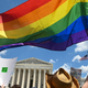 Protesters wave a Pride flag in front of the Supreme Court a day after the Court struck down Roe v. Wade.